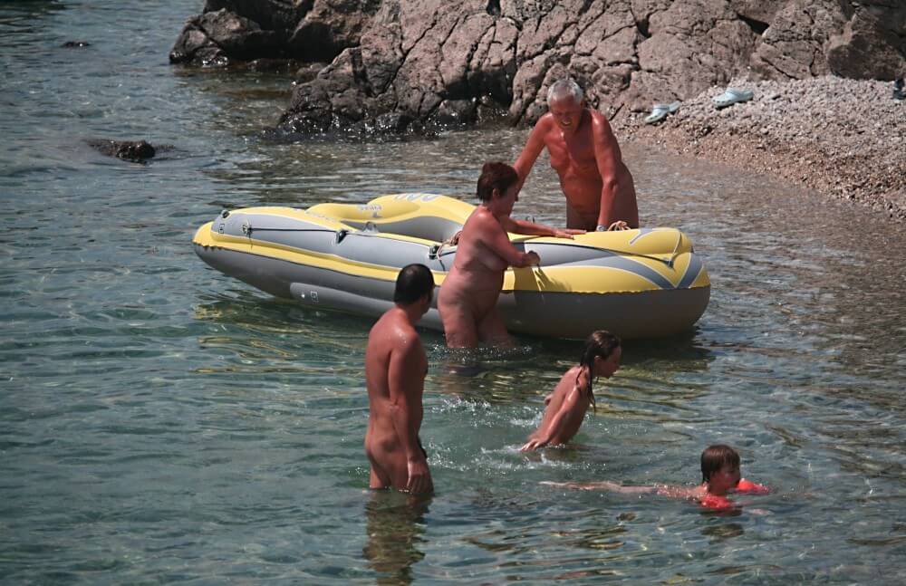 Lone Nudist in Yellow Boat photos - Naturism and environmental awareness in the modern world